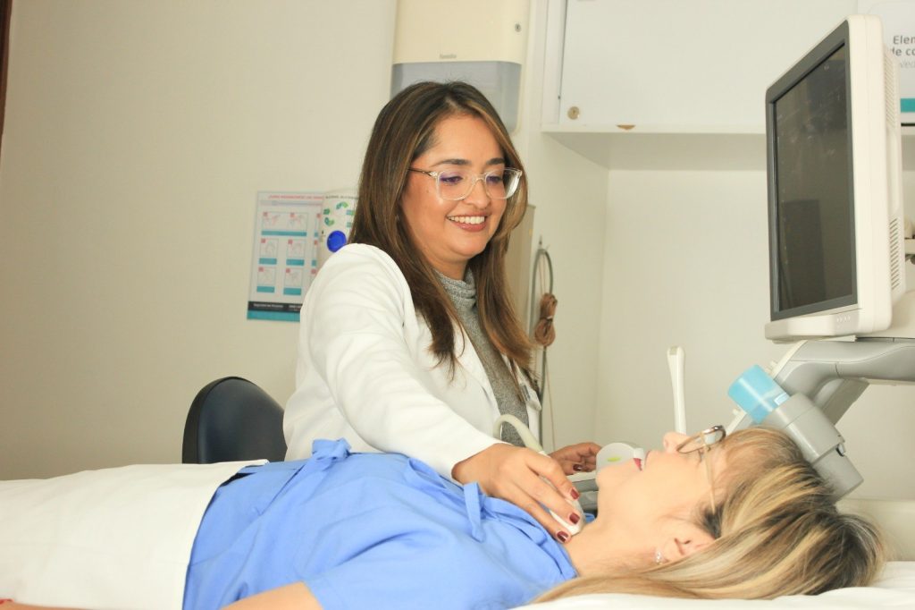 Profesional de salud realiza un estudio de ecografía a una paciente.